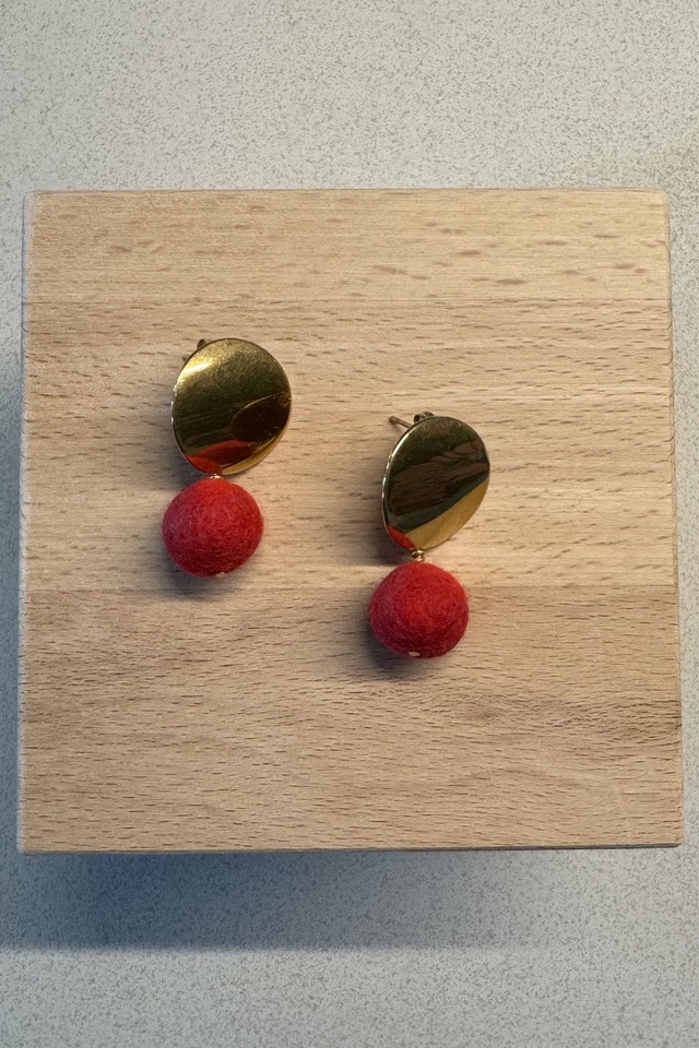 Leuchtend rote Filzkugeln an goldfarbenen Edelstahlsteckern